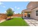 Landscaped backyard with artificial turf, stone pathways, a covered patio and an olive tree at 1000 Cetona Ct, Henderson, NV 89011