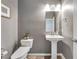 Neutral half bathroom with pedestal sink, modern toilet and textured gray walls at 1000 Cetona Ct, Henderson, NV 89011