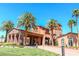 Community center exterior with stucco walls, stone accents, manicured lawns and stately palm trees at 1000 Cetona Ct, Henderson, NV 89011