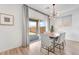 Bright dining area with a modern chandelier, white chairs, and sliding doors to the patio at 1000 Cetona Ct, Henderson, NV 89011