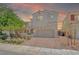 Charming two-story home at sunset with a paver driveway and low-maintenance desert landscaping at 1000 Cetona Ct, Henderson, NV 89011