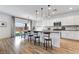 Modern kitchen with white cabinetry, stainless steel appliances, an island with bar stool seating, and wood flooring at 1000 Cetona Ct, Henderson, NV 89011