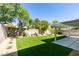 Landscaped backyard featuring a covered patio, artificial grass, and concrete pavers at 1013 Corsica Ln, Las Vegas, NV 89144