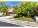 Charming two-story home featuring a well-manicured lawn, mature trees, and a two-car garage at 1013 Corsica Ln, Las Vegas, NV 89144