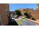 Backyard offers outdoor grill, table and chairs set, green shrubs, and manicured landscaping at 10668 Berkshire Woods Ave, Las Vegas, NV 89166