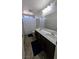 The bathroom has dual sinks with dark wood cabinetry, a shower, and a large mirror at 10668 Berkshire Woods Ave, Las Vegas, NV 89166