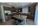 Kitchen featuring stainless steel appliances, an island with bar stools, and dark wood cabinets at 10668 Berkshire Woods Ave, Las Vegas, NV 89166