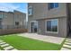 A well-kept backyard showcasing artificial turf, stepping stones, a brick patio, and direct access into the house at 11658 Midnight Melody Ave, Las Vegas, NV 89138