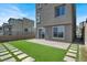 An inviting backyard with artificial turf, stepping stones, a paver patio, and seamless indoor-outdoor living at 11658 Midnight Melody Ave, Las Vegas, NV 89138