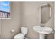 This is a half bathroom with a toilet, sink, and mirror at 11658 Midnight Melody Ave, Las Vegas, NV 89138