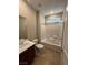 A well-lit bathroom featuring a tub, shower, and a vanity with modern fixtures and tiled floor at 11658 Midnight Melody Ave, Las Vegas, NV 89138