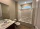 A well-lit bathroom featuring a tub, shower, and a vanity with modern fixtures and tiled floor at 11658 Midnight Melody Ave, Las Vegas, NV 89138