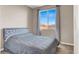 A bedroom with gray bedspread and view to the outside at 11658 Midnight Melody Ave, Las Vegas, NV 89138