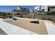 Outdoor community cornhole game area with modern multi-story homes in the background at 11658 Midnight Melody Ave, Las Vegas, NV 89138