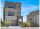 Contemporary home featuring a two-car garage, manicured landscaping, and multiple windows for natural light at 11658 Midnight Melody Ave, Las Vegas, NV 89138