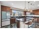 Bright kitchen featuring an island with bar stools, granite countertops, stainless steel appliances, and modern pendant lighting at 11658 Midnight Melody Ave, Las Vegas, NV 89138