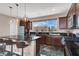 Well-lit kitchen showcasing a large island, dark cabinetry, granite countertops, and stainless steel appliances at 11658 Midnight Melody Ave, Las Vegas, NV 89138
