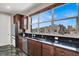 Modern kitchen with granite countertops, stainless steel appliances, dark wood cabinets, and a large window with neighborhood views at 11658 Midnight Melody Ave, Las Vegas, NV 89138
