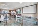 Bright living room with modern furniture, media screen, and gorgeous marble-style tile flooring at 11658 Midnight Melody Ave, Las Vegas, NV 89138
