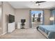 Spacious main bedroom featuring a ceiling fan, a modern desk, and a large window overlooking the neighborhood at 11658 Midnight Melody Ave, Las Vegas, NV 89138