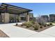 A covered pavilion with seating offers a relaxing outdoor space with drought tolerant landscaping at 11658 Midnight Melody Ave, Las Vegas, NV 89138