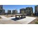 Outdoor community ping pong table with modern multi-story homes in the background at 11658 Midnight Melody Ave, Las Vegas, NV 89138