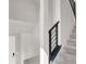Bright staircase showcasing black metal railings and natural light filtering through a nearby door at 11658 Midnight Melody Ave, Las Vegas, NV 89138
