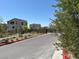 An exterior shot showing the community entrance with modern home designs and street appeal at 11658 Midnight Melody Ave, Las Vegas, NV 89138