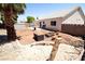 Landscaped backyard featuring a fire pit, palm tree, shed and desert landscaping at 1709 High Breeze Ct, Las Vegas, NV 89106