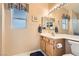 Bathroom featuring neutral cabinets, a large mirror with vanity lighting, and tile flooring at 2085 Joy View Ln, Henderson, NV 89012