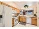 Well-lit kitchen with light wood cabinetry, white appliances, and a view into the living area at 2085 Joy View Ln, Henderson, NV 89012
