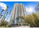 High-rise exterior view with tall palm trees and a bright blue sky in the background at 2877 Paradise Rd # 702, Las Vegas, NV 89109