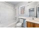 Bright bathroom featuring marble tile surround, shower-tub, and wood vanity with generous counter space at 3221 Epson St, Las Vegas, NV 89129