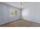 This bedroom features carpet flooring, a ceiling fan, and a window offering natural light at 3221 Epson St, Las Vegas, NV 89129