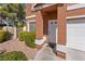 Close-up of home's entrance showcasing a well-manicured yard, front door, and attached two-car garage at 3221 Epson St, Las Vegas, NV 89129