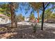 Community pool area with mature trees, lounge chairs, and rock feature at 3221 Epson St, Las Vegas, NV 89129