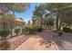 Community walkway featuring a wrought iron fence and mature trees and shrubbery at 3221 Epson St, Las Vegas, NV 89129