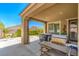 Covered patio with hot tub and BBQ grill overlooking the fenced in green backyard at 3709 Corte Bella Hills Ave, North Las Vegas, NV 89081