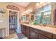 Double vanity bathroom with a glass shower, dark wood cabinets, a linen closet, and warm lighting fixtures at 3709 Corte Bella Hills Ave, North Las Vegas, NV 89081