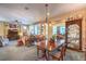 Open-plan living and dining area with chandelier, shutters, and neutral tones with a dining table as a focal point at 3709 Corte Bella Hills Ave, North Las Vegas, NV 89081