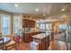 Open-concept kitchen with stainless steel appliances, granite countertops, and dark wood cabinets at 3709 Corte Bella Hills Ave, North Las Vegas, NV 89081
