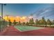 Fenced outdoor tennis court with mature trees and lighting fixtures at 3709 Corte Bella Hills Ave, North Las Vegas, NV 89081