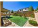 Well manicured backyard featuring artificial turf, playground set, and privacy fence at 397 Pearl Fountains Ct, Las Vegas, NV 89148