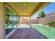 Inviting backyard features a covered patio and manicured artificial turf, perfect for outdoor activities at 397 Pearl Fountains Ct, Las Vegas, NV 89148
