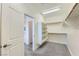 Walk-in closet with shelving and hanging rods, adjoining the Primary bathroom with wood-look tile flooring at 397 Pearl Fountains Ct, Las Vegas, NV 89148