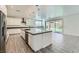 Modern kitchen featuring an island with bar seating, stainless steel appliances, and sliding glass doors to the backyard at 397 Pearl Fountains Ct, Las Vegas, NV 89148