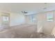 This spacious living room is naturally lit and features neutral-colored carpet and a ceiling fan at 397 Pearl Fountains Ct, Las Vegas, NV 89148