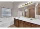 Elegant bathroom vanity with dual sinks, a large mirror, and ample lighting at 412 Carlton Kay Pl, Las Vegas, NV 89144
