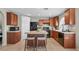A view of the eat-in kitchen with an island, wooden cabinets, and black appliances at 445 Colorful Rain Ave, North Las Vegas, NV 89031