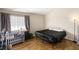 Simple bedroom with wood-look floors and a large window allowing plenty of sunlight to enter the room at 5052 S Rainbow Blvd # 201, Las Vegas, NV 89118